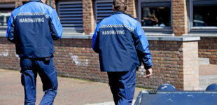 Afbeelding bij onderzoek Handhaving en overlast. Twee handhavers lopen bij een gebouw