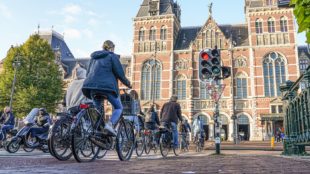 Een stroom fietsers richting het Rijksmuseum in Amsterdam